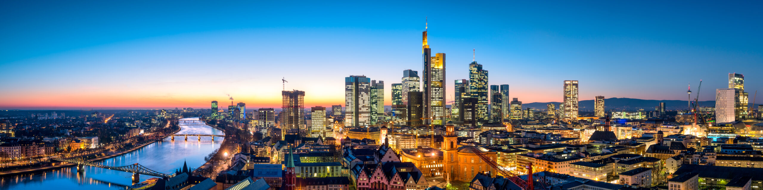 Frankfurt skyline at sunset with Main river in the foreground